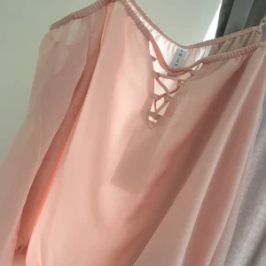  - Rosa blus i offshoulder-modell i skönt material från New Yorker. Storlek XL med fina trumpetärmar och dekorativ snörning fram.