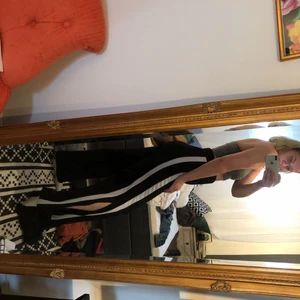  - Vida svarta byxor med två ränder på sidan. Köparen betalar frakten 