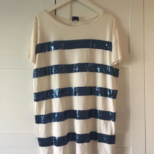  - Oversize offwhite t-shirt med blå paljetter. Passar de flesta storlekar. Använd en gång. Djur finns i hemmet. 