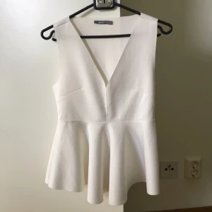  - Festlig, vit topp med djup V-ringning. Kommer från Gina Tricot och är använd 1 gång. 