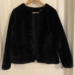 Pälsjacka  - En kort mysig pälsjacka, fejk givetvis. Från hm. Aldrig använd. Stängs med hake. 