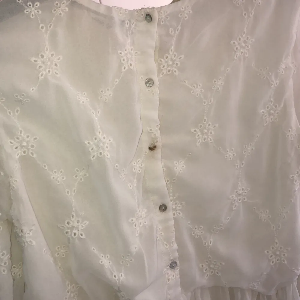 Söt vit blus från Zara i storlek S. Fint mönster på tyget. På sista bilden kan man se att knappen i mitten på ryggen är halv men fungerar att använda ändå! . Blusar.