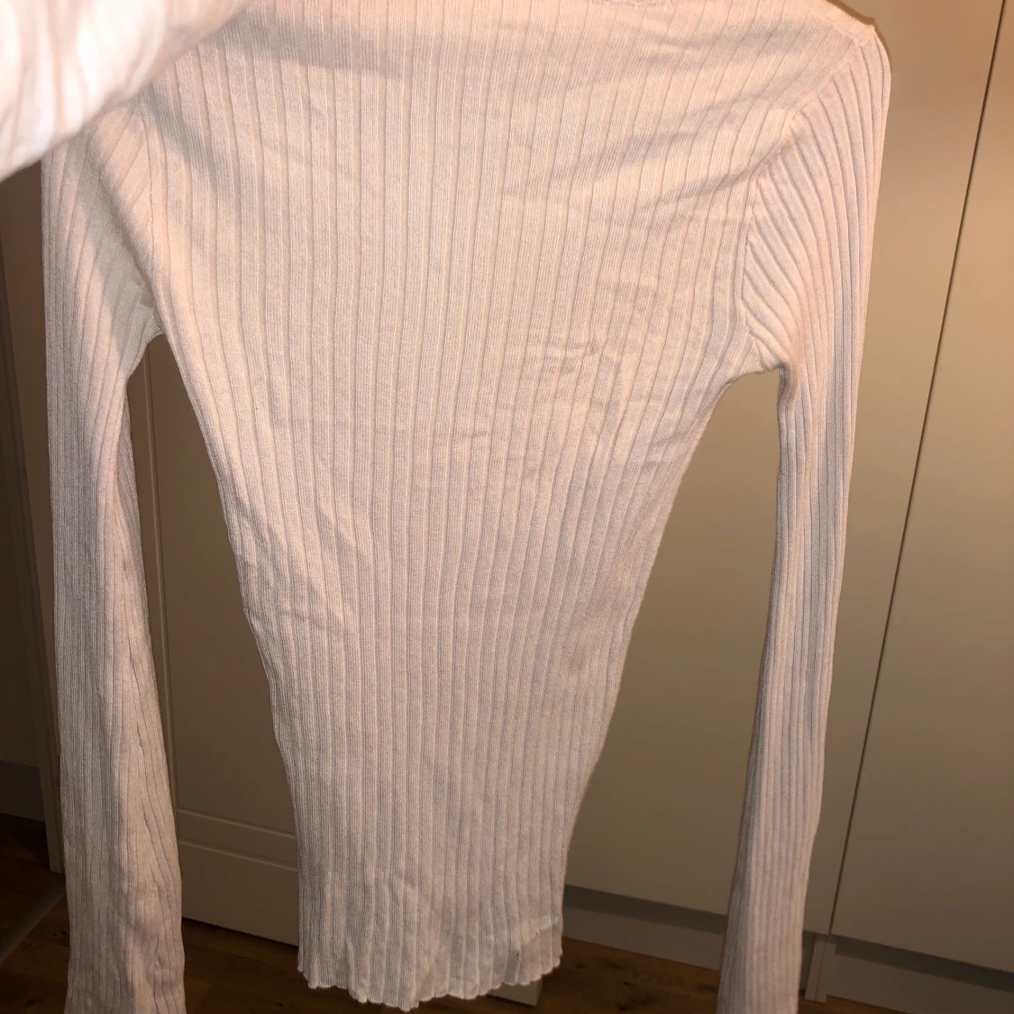 Fin tröja med utsvängda armar längst ned vid armleden