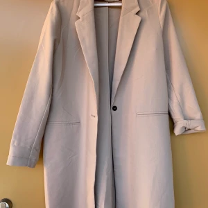 Beige kappa - Tunn beige kappa från Gina Tricot. Strl 40. Använd fåtal gånger. Frakten står köparen för.