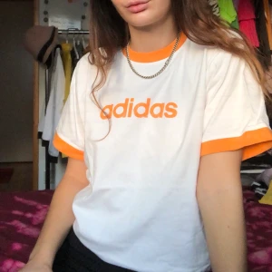Retro Adidas tshirt - Retro Adidas tshirt med orange detaljer, står ingen storlek men skulle säga att den är som en medium ✨ Möts upp i Göteborg annars står köparen för frakten
