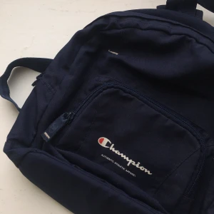 1990s CHAMPION MINIRYGGSÄCK 💙 - 1990s marinblå miniryggsäck från Champion. Lite sliten inuti, se bild. 30 kr plus porto. 💙