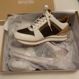 Michael Kors Skor  - Oanvända Michael Kors skor i storlek 36. Köpta för 1900 kr och prislappen sitter kvar. Kartongen kommer med på köpet om önskat. Kommer aldrig att användas och kan lika gärna köpas av någon som vill ha dem! Frakten ingår i priset och priset kan  diskuteras vidare.