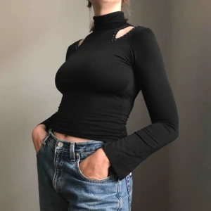  - Frakt ingår! • Svart polotröja i mycket stretchigt material med ”cutout”-detaljer vid axlarna och lite utställda ärmar • ingen storlek men kan passa XS-M beroende på hur tight man vill att den sitter (jag har vanligtvis S som referens) 