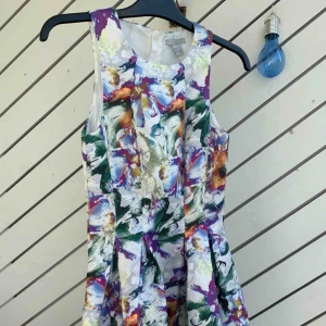  - En jättefin blommig klänning utsvängd nedtill , med dragkedja baktill ! Helt ny me etikett på!  Köparen står för frakten! 