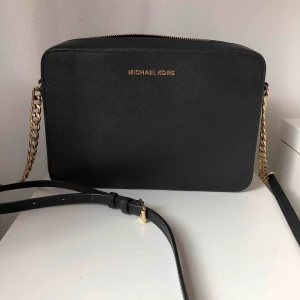  - Svart crossover bad från Michael Kors med gulddetaljer. Väskan är i nyskick. Nypris 2000kr