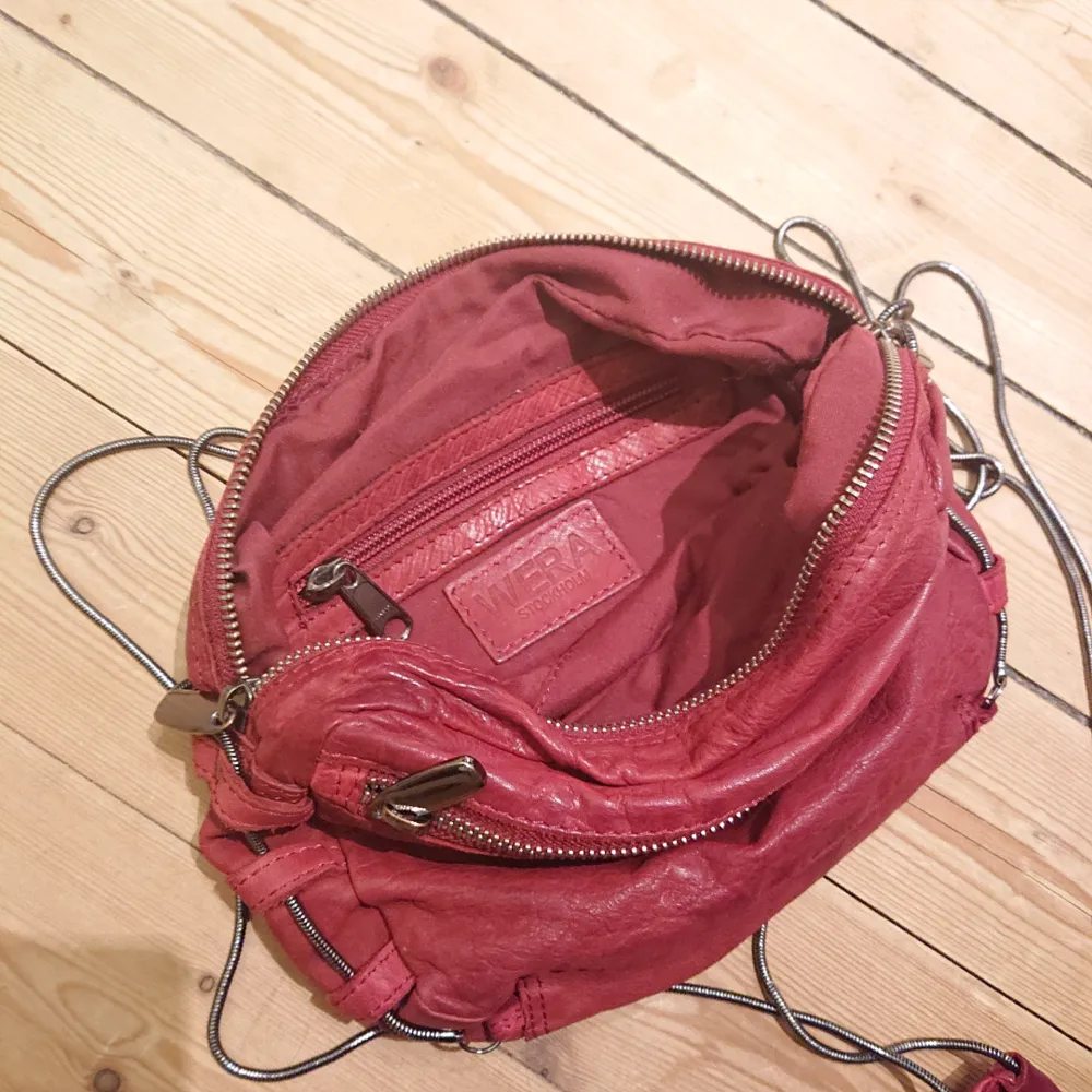 Mindre väska i vinrött läder som rymmer det nödvändigaste och lite till, från Wera Stockholm, i fint skick! . Väskor.