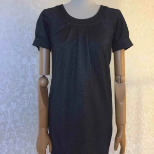  - Klänning, slutar ovanför knäna, knäppning i bak