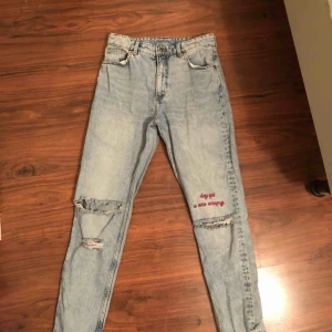  - Blå mom jeans med hål på knäna samt rosa text