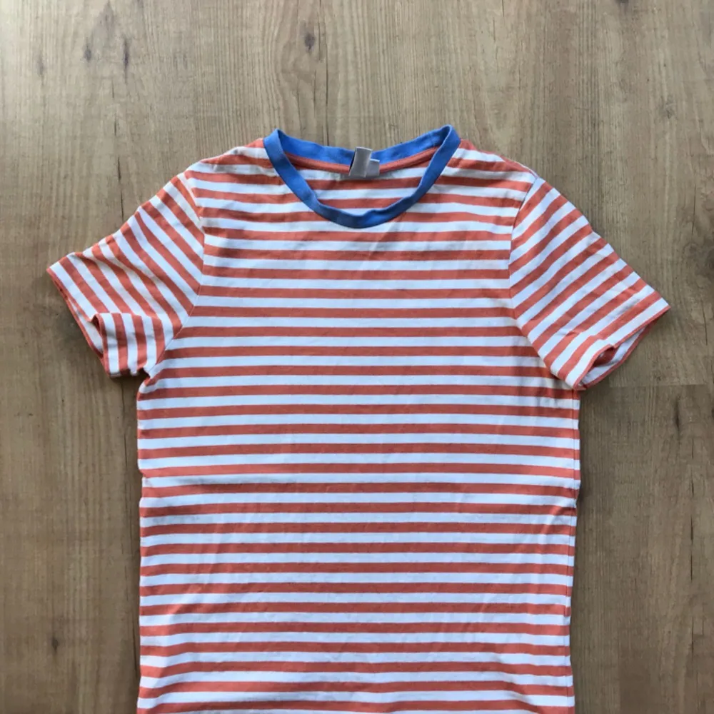 T-shirt from & other stories. Coral striped with sky blue collar line. It’s very lovely especially for the summer days. Sturdy cotton for a shirt, not the thin kinds that breaks after a few wears. . T-shirts.