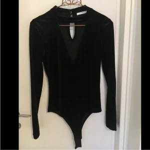  - Svart, V-ringad sammetsbody med låg polokrage. Endast använd 1 gång så jättefint skick! Kan mötas upp i Sthlm, annars står köparen för frakten. 