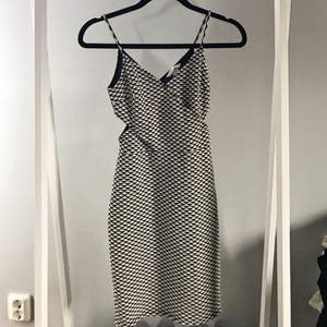 Svart-vit mönstrad klänning från H&M med cut-out detalj. Aldrig använd 