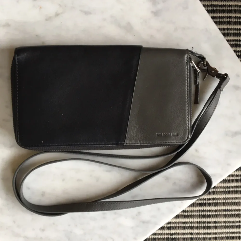 Plånbok/väska i läder från The Local Firm. Fungerar även utmärkt som reseplånbok! Lång avtagbar axelrem. . Väskor.