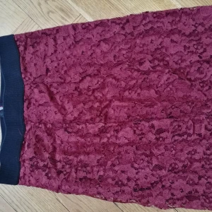  - Kjol i vinröd spets. Använd en gång. Dragkedja bak.