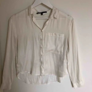  - Vit-cream färgad siden blus. En ficka på vänstra sidan. I toppskick och bra kvalité, aldrig använd. En bra skjorta- blus som går att styla på många olika sätt. Storlek S, passar även XS och M. Frakt tillkommer.