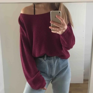  - Mörklila/vinröd stickad tröja från NA-KD med vid urringning. Är i fint skick och är lite större i storlek, passar en M (frakt tillkommer). 