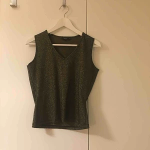  - Partytopp från Lindex (köpt secondhand), är guldglittrigt men svårt att fånga nyansen på bild. Stretchig så kan passa större storlekar! 38/40 står det på lappen.