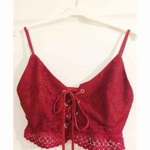  - Crop top i röd spets med snörning i fram. Virkad i nedre kant. Storlek 8 men passar 34/36. Använd 1 gång. 