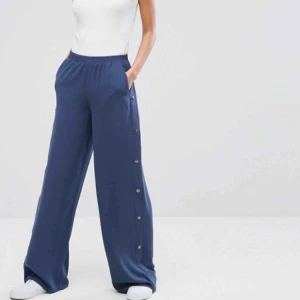  - Ett par vida byxor med dekorativa knappar från ASOS i storlek S.