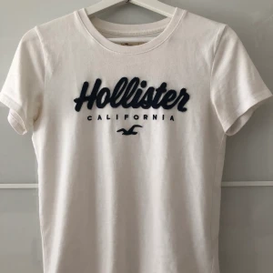 Hollister t-shirt - Vit t-shirt ifrån hollister med marinblått tryck🤍 använd ett fåtal gånger 