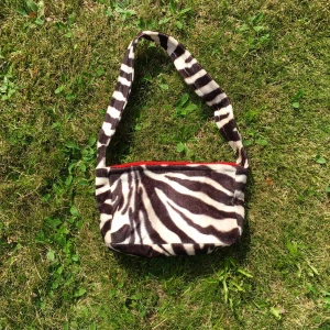 Zebraväska - Väska jag sytt själv i luddigt zebratyg. Den har tre tryckknappar inuti som håller väskan stängd. Ställ jättegärna frågor🥰 