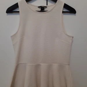 H&M peplumtopp - Fin, naturvit peplupeplum-topp från H&M. Sparsamt använd. Lite tjockare tyg så man ser inte genom. Mycket bra skick!