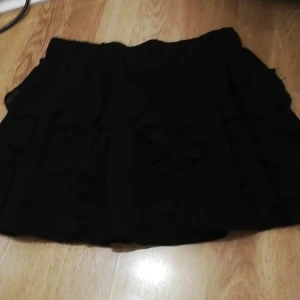 En kjol - En svart kjol från h&m storlek 36 