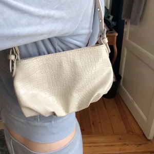 Secondhand väska  - En krokodil inspererad väska, som jag säljer då den inte kommer till användning. Skicket på väskan är 10/10. Frakten ingår ej och går på 40kr