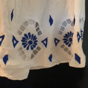 Märkes linne - Snyggt märkes linne! Ett vitt linne med blå broderier som detaljer samt en liten v ringning!