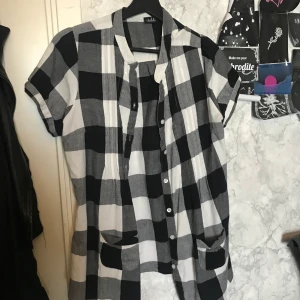 Svartvit flanellblus - Gratis frakt! Svartvit flanellblus med två fickor fram, knappar hela vägen, använd några ggr men bra skick, stl 42 men passar även till de med mindre stl