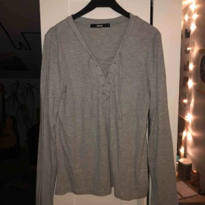 - Grå långärmad tröja men snörning. Köparen står för frakten, kan mötas upp i Lund