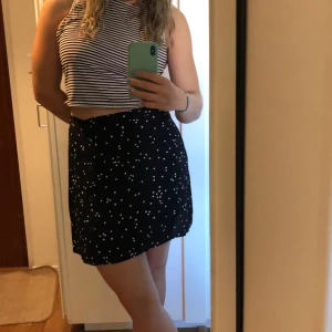 Kjol strl 44 - Prickig kjol i tunt material. Knappar som detaljer fram. Sparsamt använd pga för stor. Frakt tillkommer.