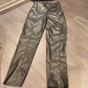 Byxor skinneffekt  - Byxor med skinneffekt. 1dm lång dragkedja på sidan. Lite stretch material. Helt nya, aldrig använda! 