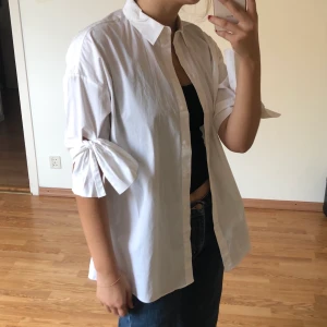 Armani exchange skjorta - En vit Armani exchange skjorta med ett par knytbara rosetter vid ärmarna. Prislappen är fortfarande kvar och skjortan har endast testats några gånger. 