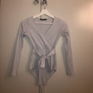 Body - Ljusgrå body från boohoo med knytband i midjan. Aldrig använd.