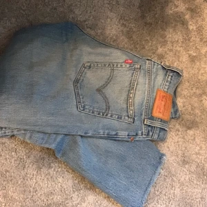 Levis 501 - Högmidjade, blå. En liten fläck på framsida lår. 
