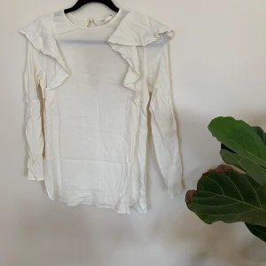 Fin vit blus med volanger storlek 36 - Använd fåtal gånger. 