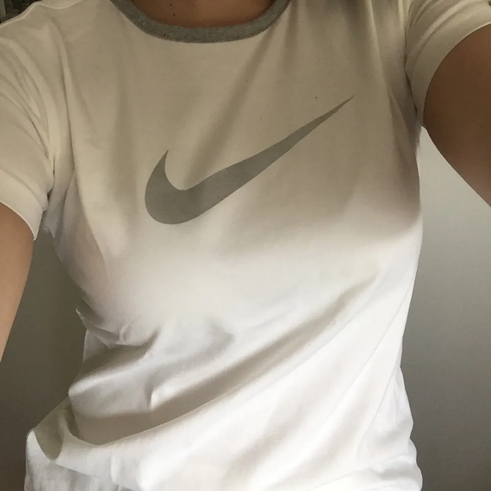 Vintage Nike Athletic T-shirt med grå och silvriga detaljer i stretchigt vitt tyg (90% bomull). T-shirts.