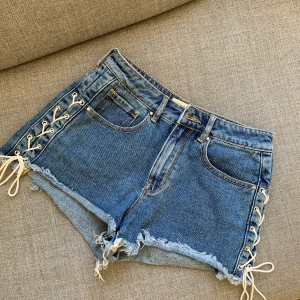 Shorts - Högmidjade jeans shorts med snörning på sidorna, från Pacsun. Använda 1 gång. Frakt tillkommer