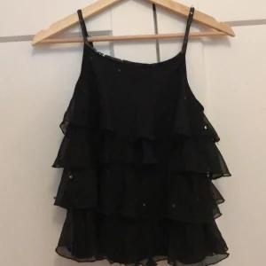 Svart linne med paljetter strl 146/152 - Har används några gånger och är i hyfsat bra skick. 