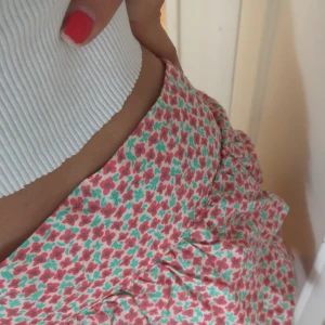 Rosa blommig kjol - Aldrig använd, endast testad! Super gulligt men sitter völdigt kort på mig eftersom det är en barnstorlek. Storlek 158, 12-13 år. Funkar även som topp, vilket jag skulle föredra. 