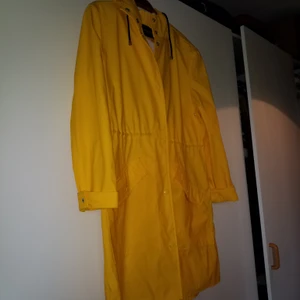 Klassisk gul regnjacka/rock - Klassiskt gul regnrock i typ nyskick. Snören i midjan och huva!