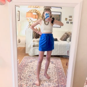 Sportig blå kjol - Kort blå kjol med svarta ränder på vardera sida och snörning i midjan! Jättecool färg, lyser typ!!💙🪐✨