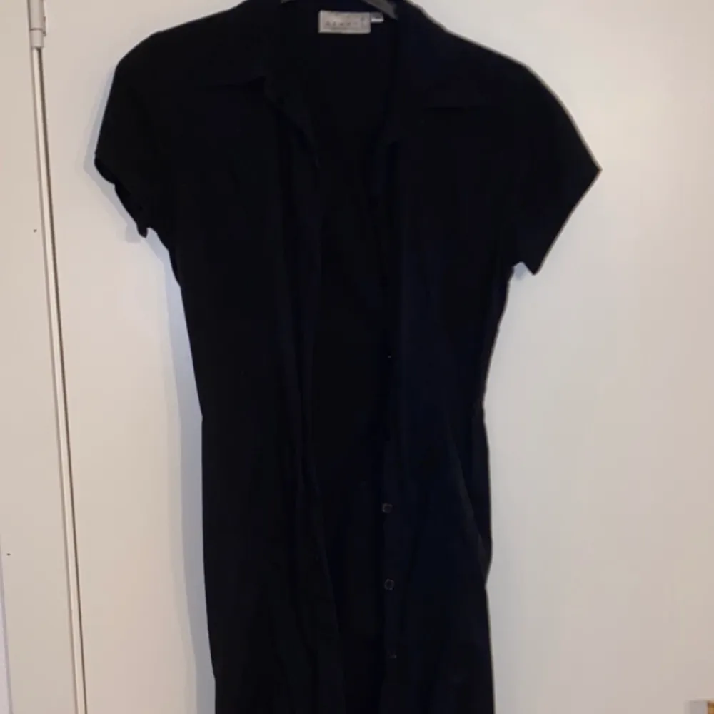 En svart klänning som även kan användas som en cardigan i storlek 38.. Klänningar.