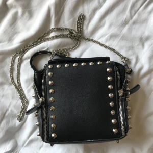 Väska med nitar⚡️ - Väska från Zara. Köpt för ganska länge sen så tror ej den går att köpa längre. väskan är ca 18 cm bred och ca 18 cm hög. kom gärna privat med frågor. budgivning avslutas måndag 23:59. Bud på 365kr