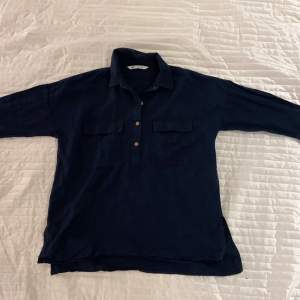 Mörkblå skjorta med bruna knappar och bröstfickor i linnetyg. Köpt från Zara i strl S. Använd 1 gång. 